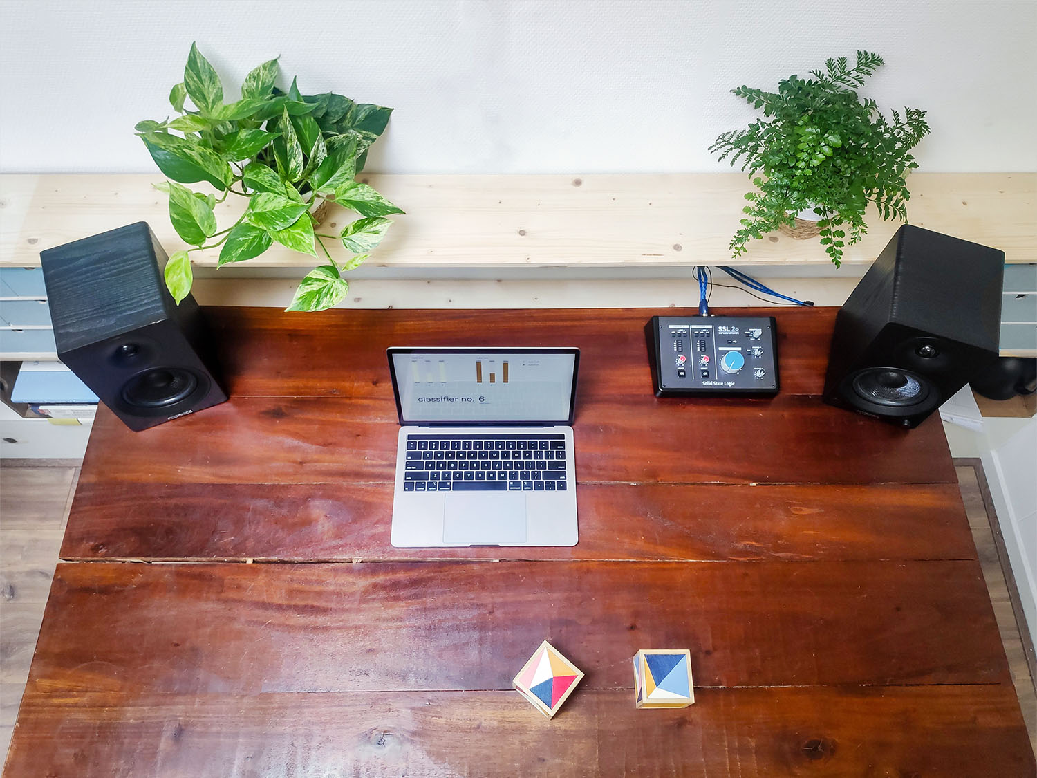 Overhead photo of Ml.cubes prototype next to a laptop showing a graphical user interface. Also on the wooden desk is a small recording console. 